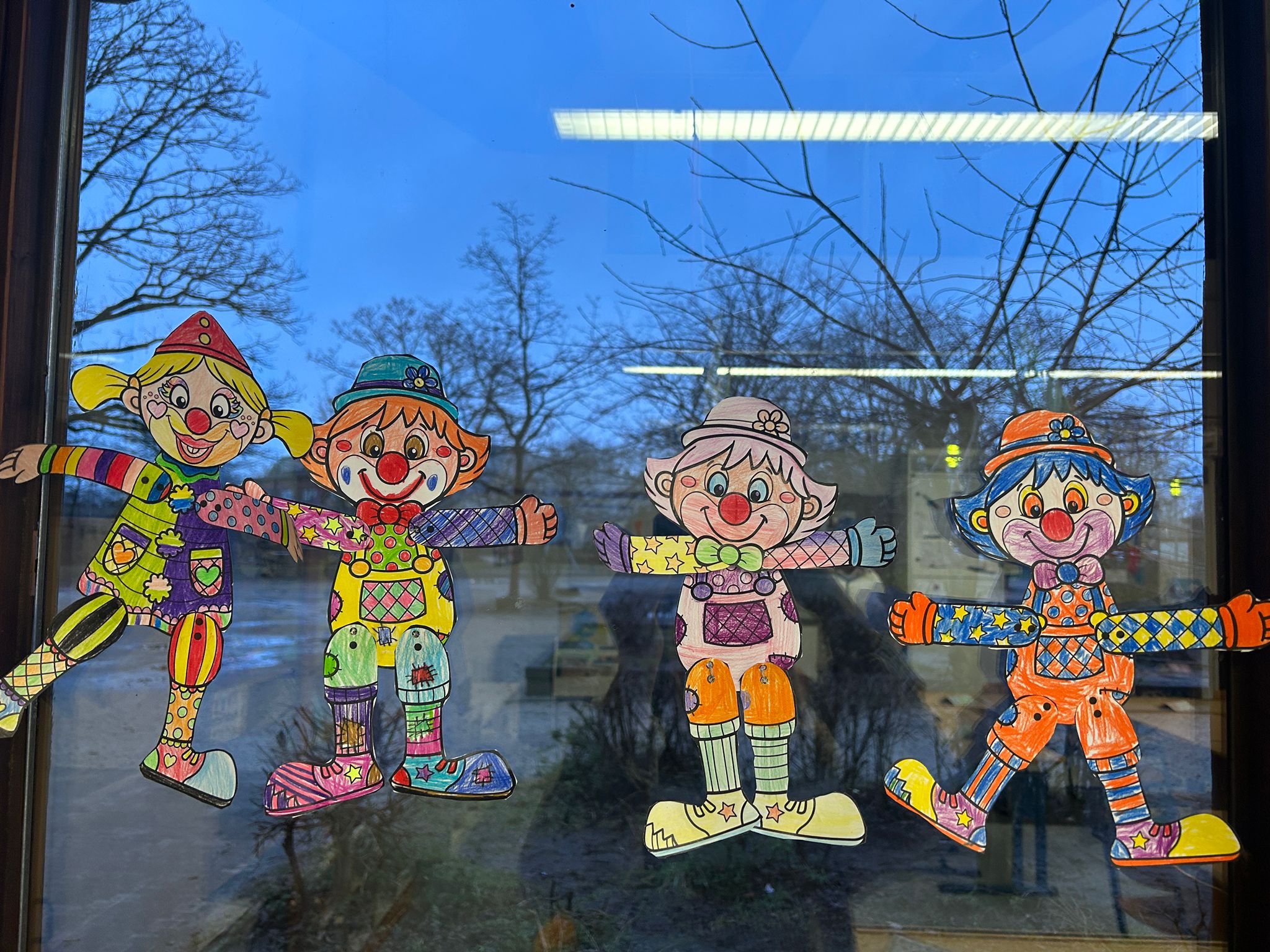Fensterdekoration: Gebastelte Hampelmänner mit Clownsnase